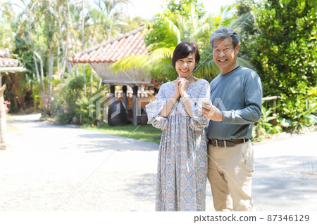 Married couple trip-Sightseeing in Onna village, Okinawa Sightseeing while checking with a smartphone 87346129