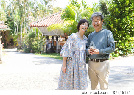 夫妻旅行-沖繩恩納村觀光 一邊用智能手機確認一邊觀光 87346135