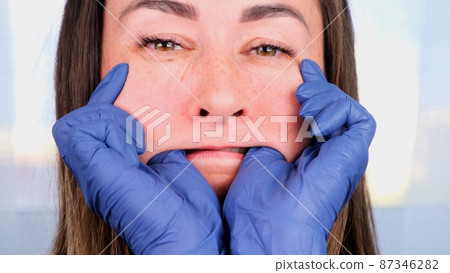 female doctor cosmetologist gives buccal facial massage to herself, teaching and showing Intra oral female doctor cosmetologist gives buccal facial massage to herself, teaching and showing Intra oral 87346282