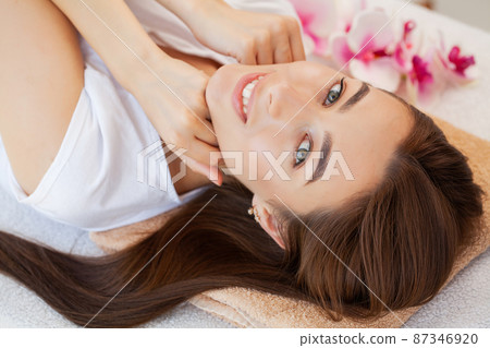 Beautiful girl has a facial massage in a beauty clinic. 87346920