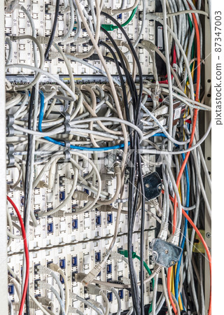 server room rack with tangled network cables creating messy untidy network system 87347003
