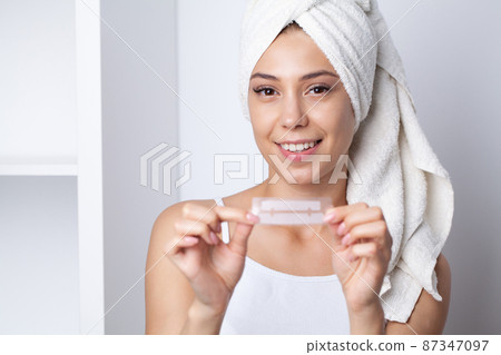 Beautiful Young Girl With White Teeth Holding in Hands Stripes For Teeth Whitening Beautiful Young Girl With White Teeth Holding in Hands Stripes For Teeth Whitening 87347097