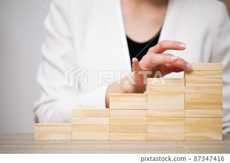 Fingers climbing the stairs made with wooden blocks. Fingers climbing the stairs made with wooden blocks. 87347416