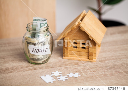 Savings money jar full of coins concept for saving or investment for a house 87347446