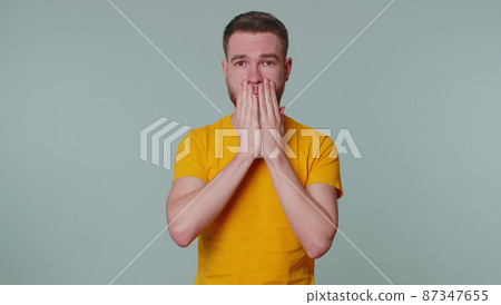Frightened scared man closing his mouth gestures no, refusing to tell terrible secret, truth 87347655