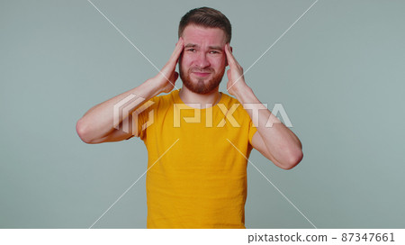 Man rubbing temples to cure headache problem, suffering from tension and migaine, stress, pain 87347661