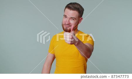 Bearded man raises thumbs up agrees or gives positive reply recommends advertisement likes good 87347773
