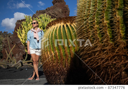 Female tourist sightseeing at tropical cactus garden in Guatiza village, Lanzarote, Canary Islands, Spain. 87347776
