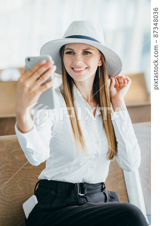 Enjoy traveling. Beautiful woman taking selfie in airport, waiting for boarding. Enjoy traveling. Beautiful woman taking selfie in airport, waiting for boarding. 87348036
