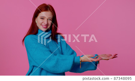 Girl pointing empty place, advertising area for commercial text, copy space for goods promotion Girl pointing empty place, advertising area for commercial text, copy space for goods promotion 87348095