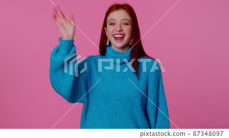 Girl teenager smiling friendly at camera and waving hands gesturing hello or goodbye, welcoming Girl teenager smiling friendly at camera and waving hands gesturing hello or goodbye, welcoming 87348097