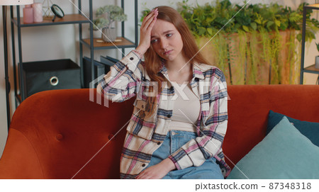 Displeased young woman rubbing temples to cure headache problem, suffering from tension and migaine Displeased young woman rubbing temples to cure headache problem, suffering from tension and migaine 87348318