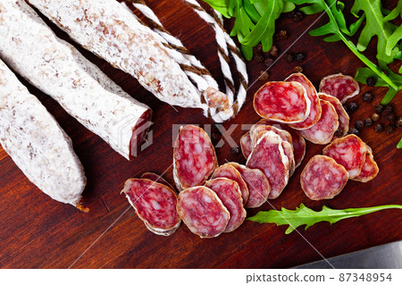 Traditional spanish thin salami sausage Fuet, sliced 87348954