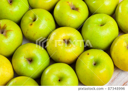 Many of ripe green apples on the wooden table Many of ripe green apples on the wooden table 87348996