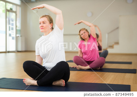 Three women are sitting in a lotus pose Three women are sitting in a lotus pose 87349495