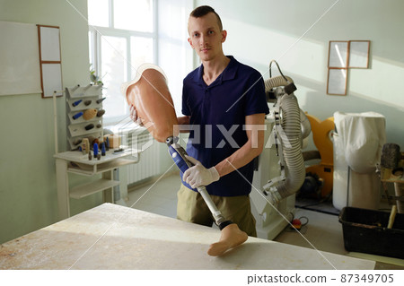 Young specialist of manufactory holding ready leg prosthesis Young specialist of manufactory holding ready leg prosthesis 87349705