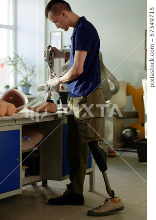 Worker of modern prosthetic production factory assembling new artificial limb Worker of modern prosthetic production factory assembling new artificial limb 87349718
