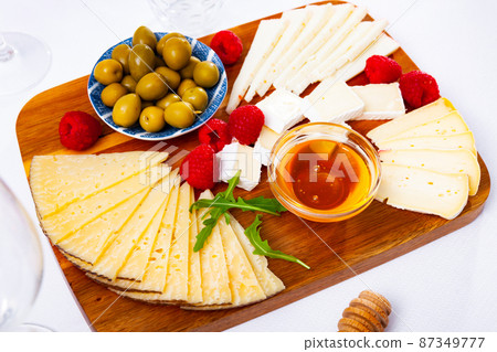 Different types of cheese sliced and served on plate Different types of cheese sliced and served on plate 87349777