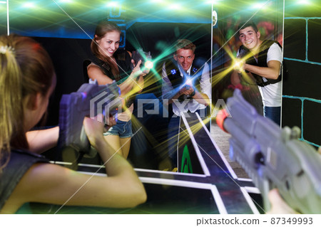Excited people playing enthusiastically laser tag game Excited people playing enthusiastically laser tag game 87349993