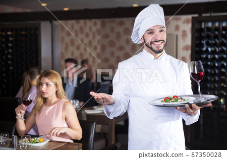 chef with dishes on serving tray welcoming chef with dishes on serving tray welcoming 87350028