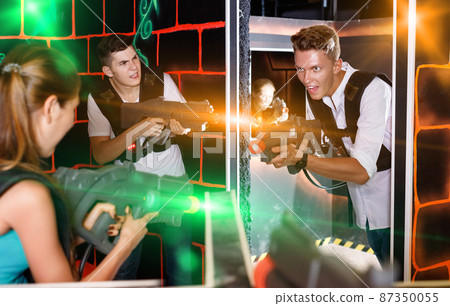 Two laser tag teams playing enthusiastically and aiming at each 87350055