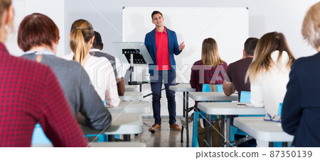 Male teacher lecturing to students 87350139