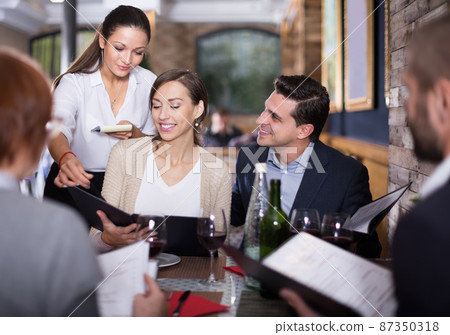 girl the waiter recommends dishes to visitors 87350318