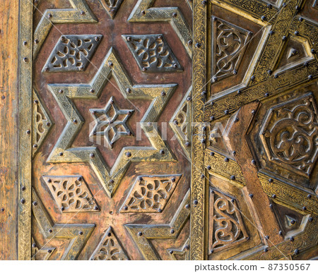 Ornaments of the bronze-plate door of an old mosque Ornaments of the bronze-plate door of an old mosque 87350567