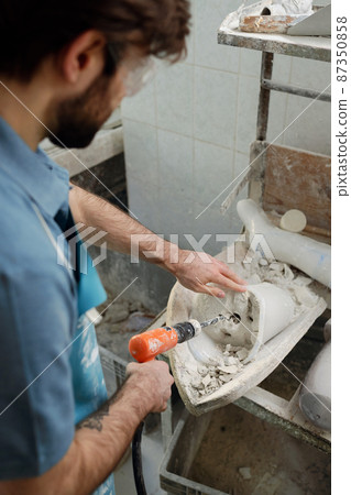 Above angle of young worker of prosthetic factory drilling plaster cast Above angle of young worker of prosthetic factory drilling plaster cast 87350858