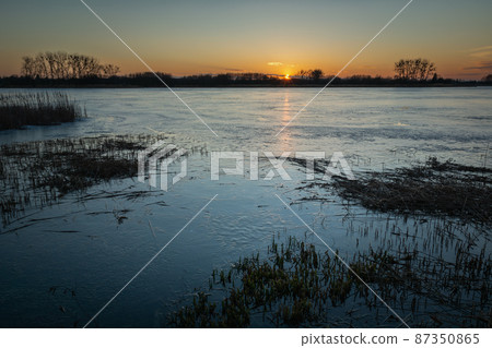 Evening view of an icy lake during sunset, Stankow, Poland Evening view of an icy lake during sunset, Stankow, Poland 87350865