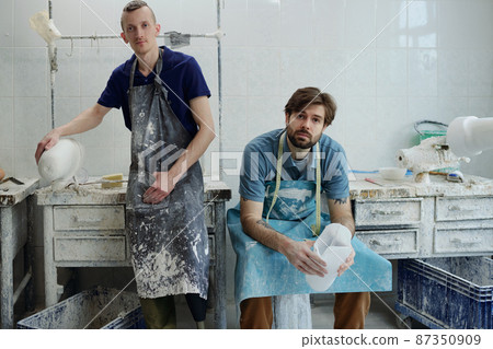 Staff of contemporary prosthetic factory in aprons looking at camera 87350909