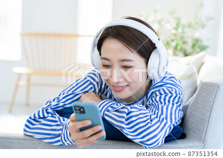 Headphones smartphone living room female 87351354