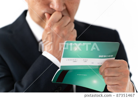 A businessman who is worried about looking at his passbook 87351467