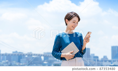 Business city blue sky smartphone woman 87353480
