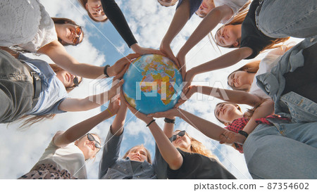 Earth conservation concept. 11 girls hug the earth globe with their hands. 87354602