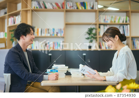 Young men and women reading books and holding study sessions in the office Young men and women reading books and holding study sessions in the office 87354930