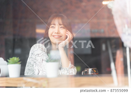 Young woman in a cafe looking through the window 87355099
