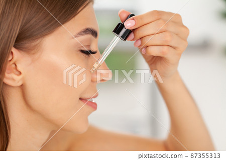 Beautiful woman fresh healthy skin looking on mirror makes makeup 87355313