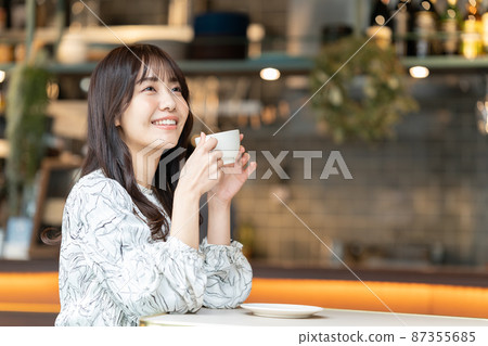 Young woman drinking coffee in a cafe Young woman drinking coffee in a cafe 87355685