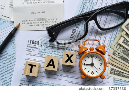 Text on wooden block cube with Tax forms 1040. U.S Individual Income Tax Text on wooden block cube with Tax forms 1040. U.S Individual Income Tax 87357388