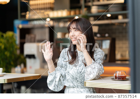 年輕女子在咖啡館打電話 87357514