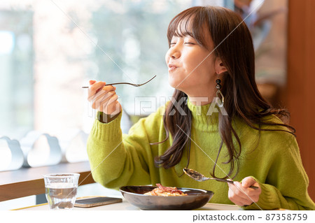 在咖啡館吃意大利面的年輕女人 87358759