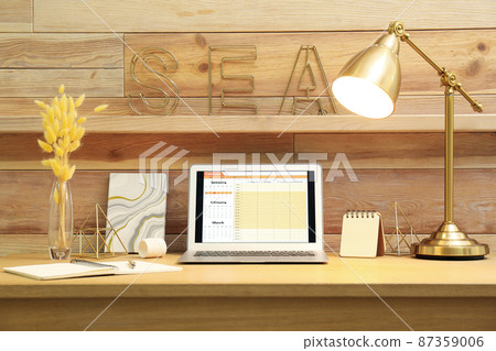 Modern laptop with calendar on screen in office Modern laptop with calendar on screen in office 87359006