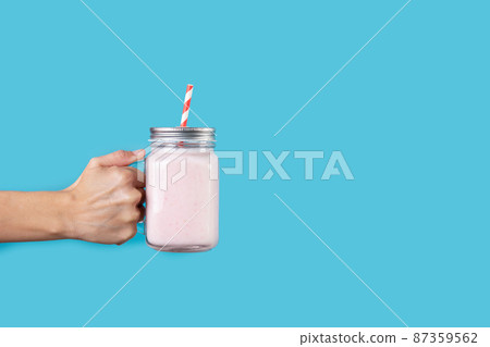 Hand with strawberry smoothie jar Hand with strawberry smoothie jar 87359562