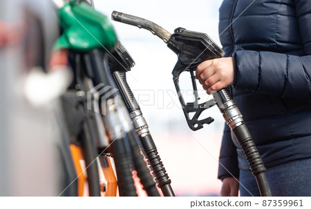 High prices of petrol and diesel fuel ath the petrol station, young woman refueling the car, economic crisis concept 87359961