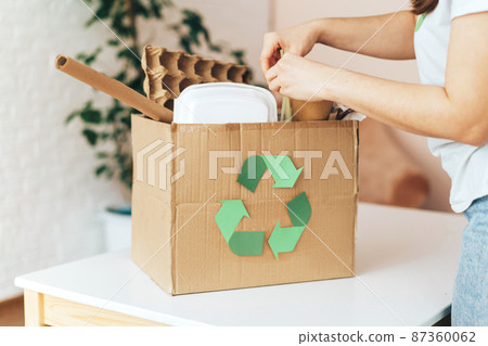 Girl puts garbage in recycling paper box Girl puts garbage in recycling paper box 87360062