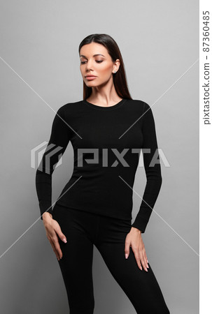 Woman wearing thermal underwear on grey background Woman wearing thermal underwear on grey background 87360485