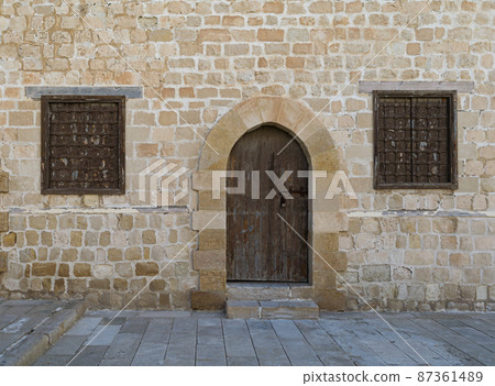 Door and two windows of one of the rooms surrounding the main yard of the citadel of Alexandria, Egypt 87361489