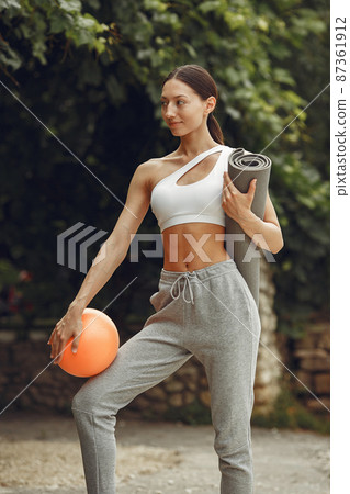 Woman in a sports clothes at the summer park Woman in a sports clothes at the summer park 87361912