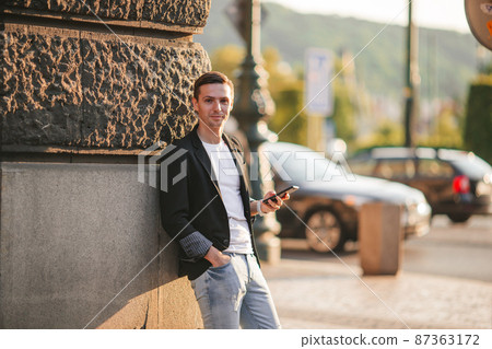 Young caucasian man walking on the street outdoor 87363172